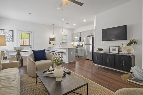 A modern living room with a grey sofa, a coffee table, and a television on the wall.