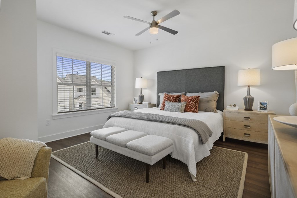A bedroom with a ceiling fan, wood floors, and double window at Turnberry Park Luxury Rental Homes in Gardendale, AL