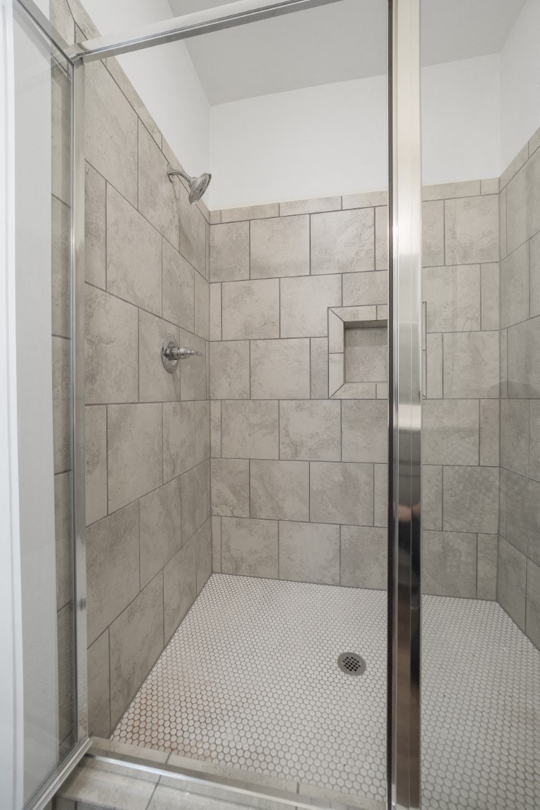 A shower with a glass door and tiled walls at Turnberry Park Luxury Rental Homes in Gardendale, AL