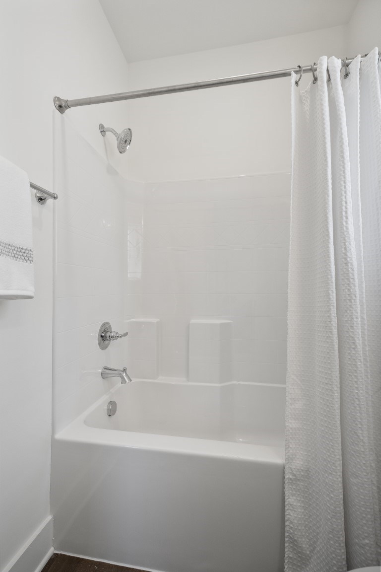 A white bathroom with a tub and shower at Turnberry Park Luxury Rental Homes in Gardendale, AL