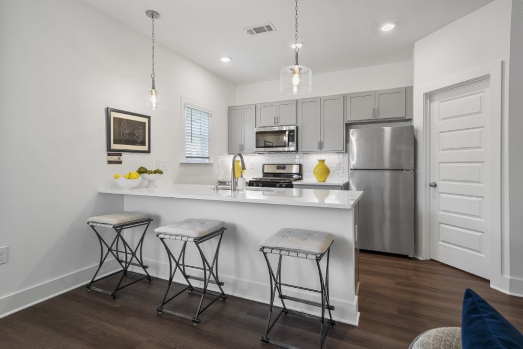 A modern kitchen with stainless-steel appliances and wood floors at Turnberry Park Luxury Rental Homes in Gardendale, AL
