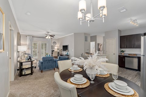 A dining room with a table set for a meal.
