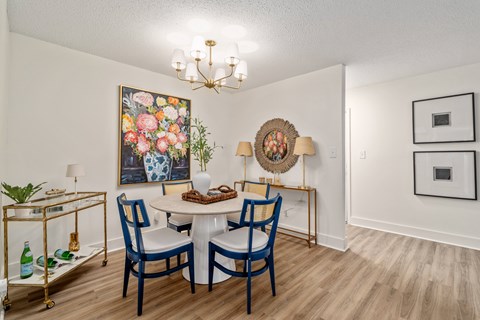 A dining room with a white table and blue chairs.
