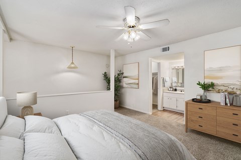 A bedroom with a large bed and a ceiling fan.