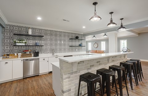 a kitchen with a marble counter top and black stools