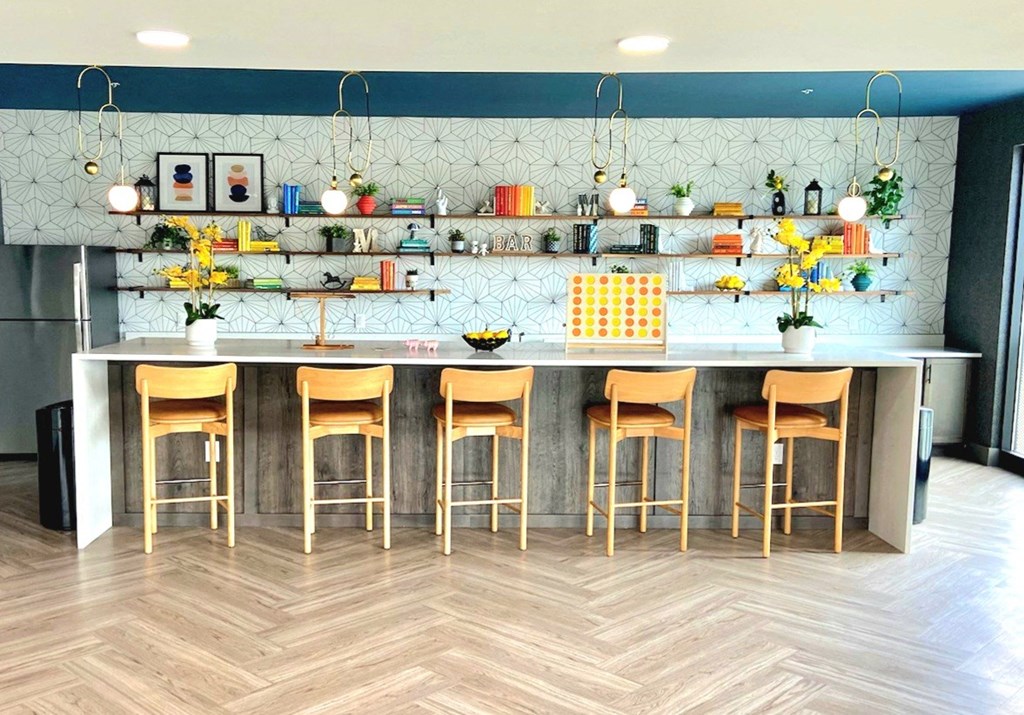 a kitchen with a long counter and a bunch of stools in front of it
