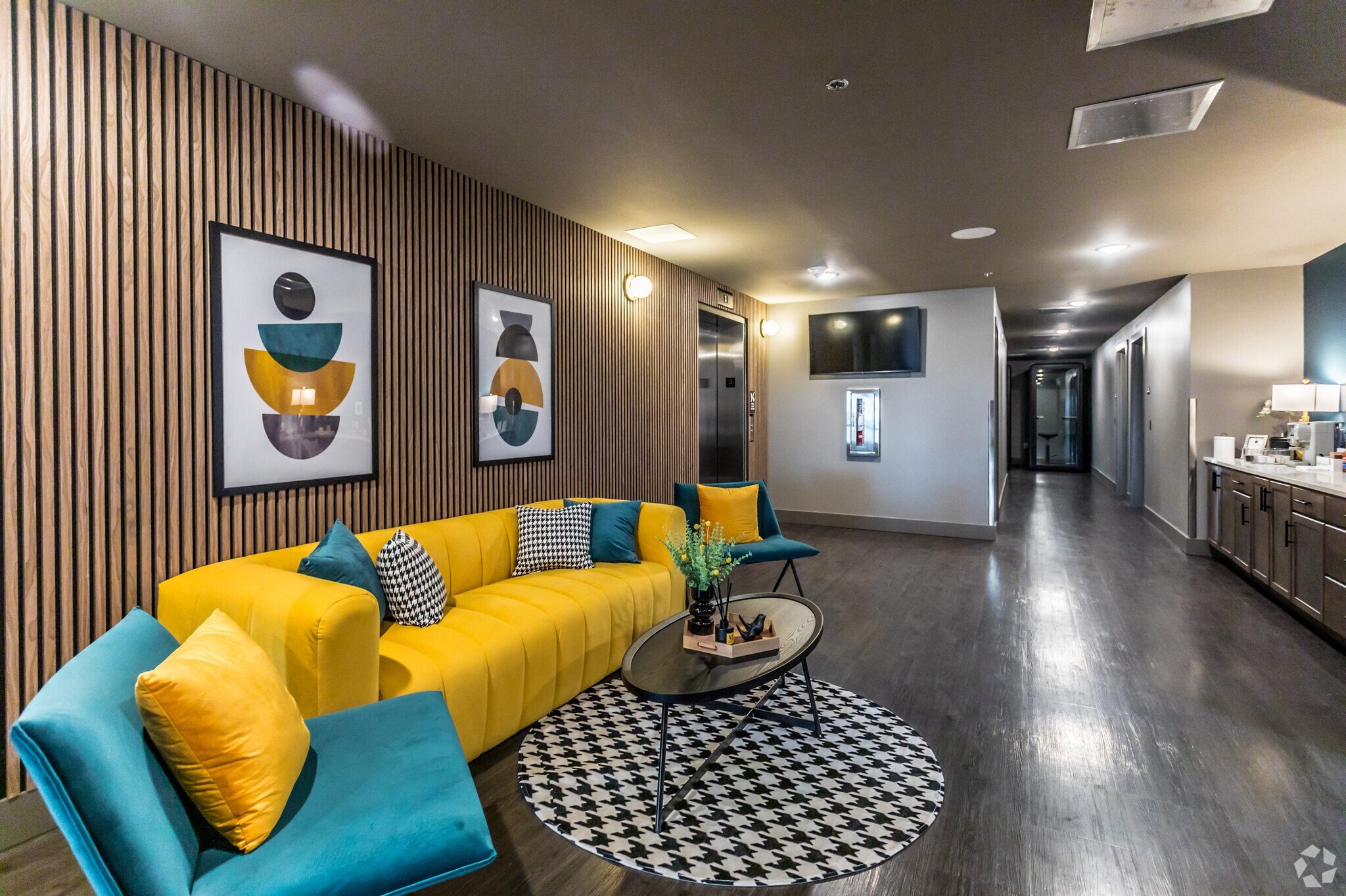 a living room with a yellow couch and blue chairs