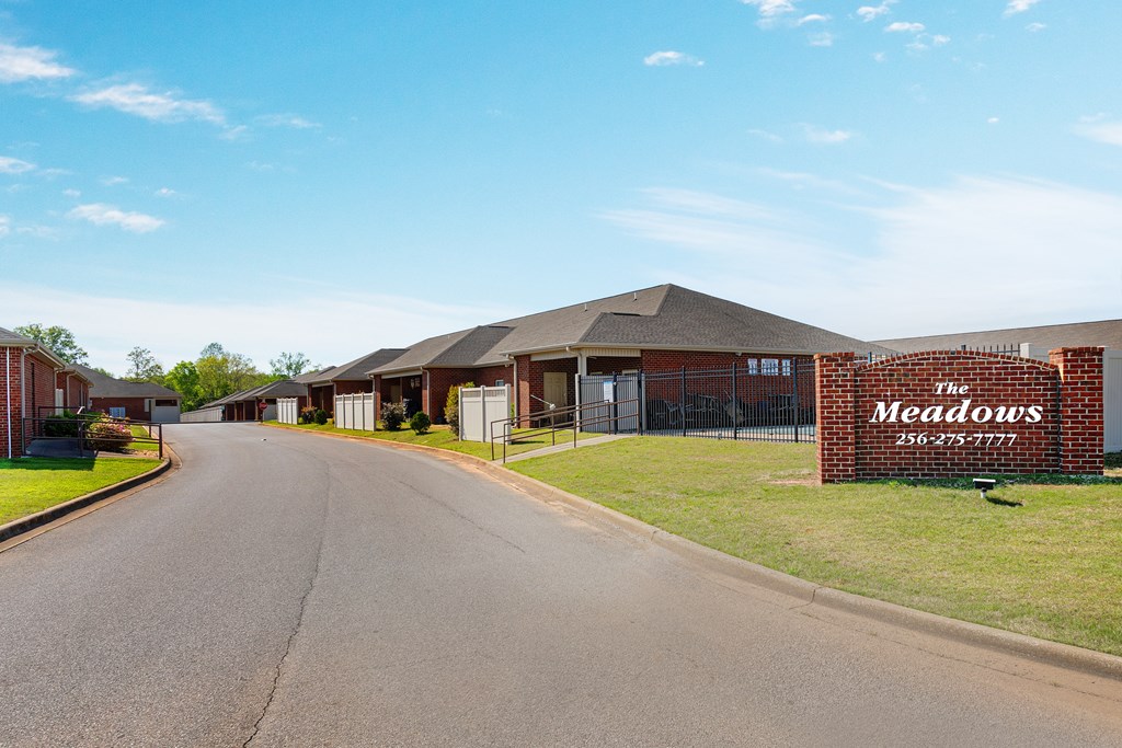 The Meadows is a residential complex with a long driveway leading to the main building.