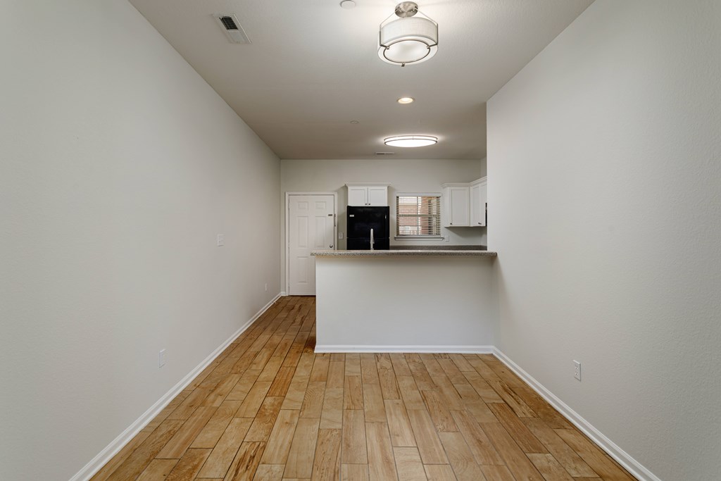 A room with wooden flooring and white walls.