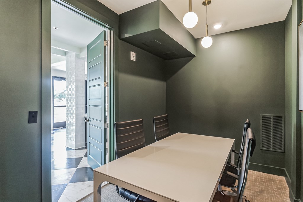 a dining room with a white table and chairs and a green wall
