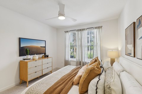 A bedroom with a large bed and a painting on the wall.