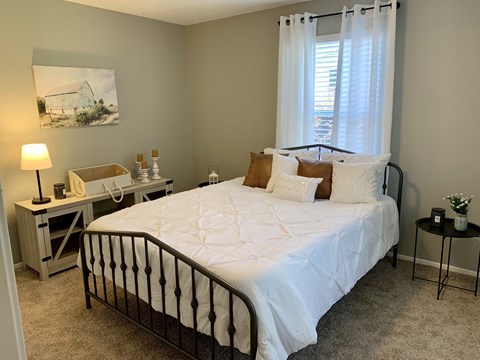 Bedroom with window and carpet at The Avery at Auburn Apartments in Auburn, AL