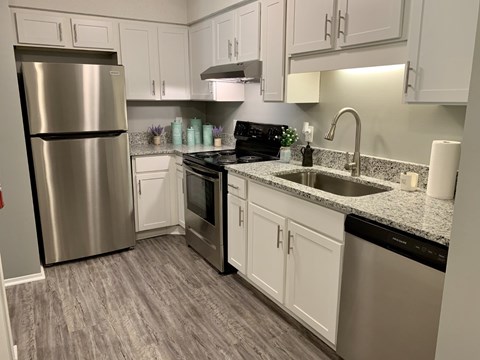 A kitchen with a stainless steel refrigerator and a black dishwasher.