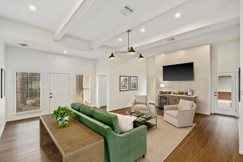 A living room with a green couch and a wooden coffee table.