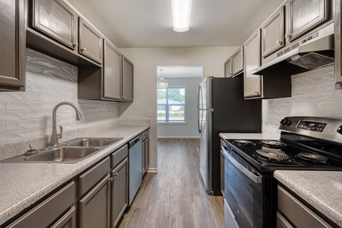 A kitchen with a black refrigerator and stove.