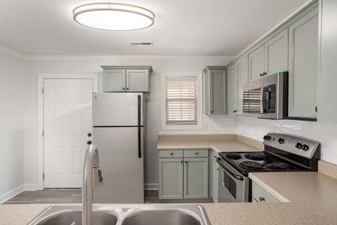 A kitchen with a stainless steel refrigerator and a stove top oven.