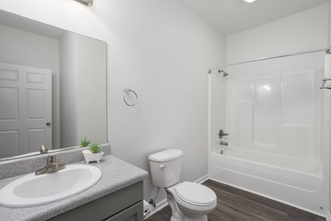 A white toilet sits next to a sink in a bathroom.