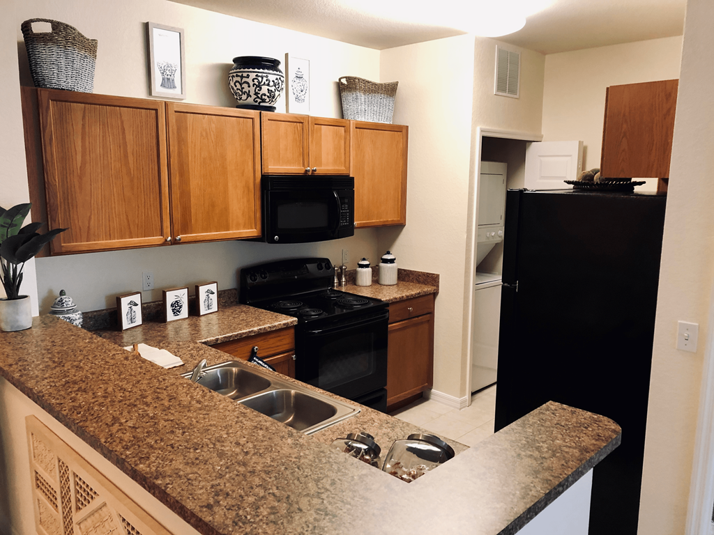 a kitchen with black appliances and granite counter tops