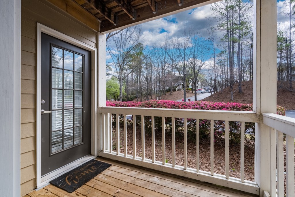A wooden front patio with white railing at Summerchase at Riverchase in Hoover, Alabama.
