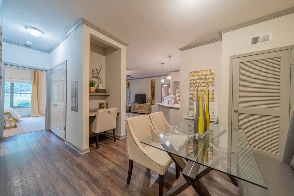 a living room and dining room with a glass table and chairs