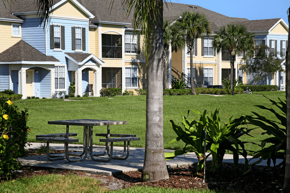 a picnic table in a park in front of some houses