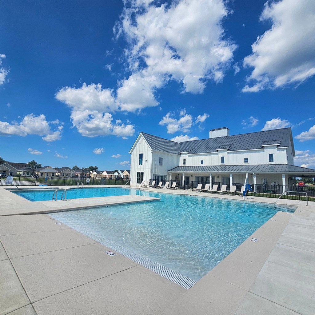 a large swimming pool with a white building in the background at The Cottages at Foley Farms apartments in Foley, AL