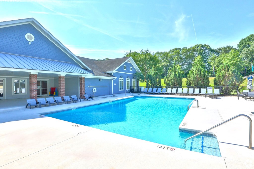 the swimming pool at the resort style pool house with chairs around it