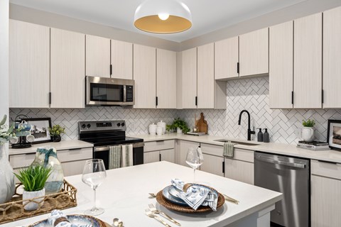 A modern kitchen with a white countertop and a microwave above it.