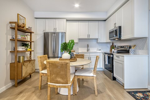 A kitchen with a table and chairs in the middle of it.