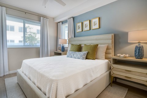 A bedroom with a large bed and a ceiling fan.