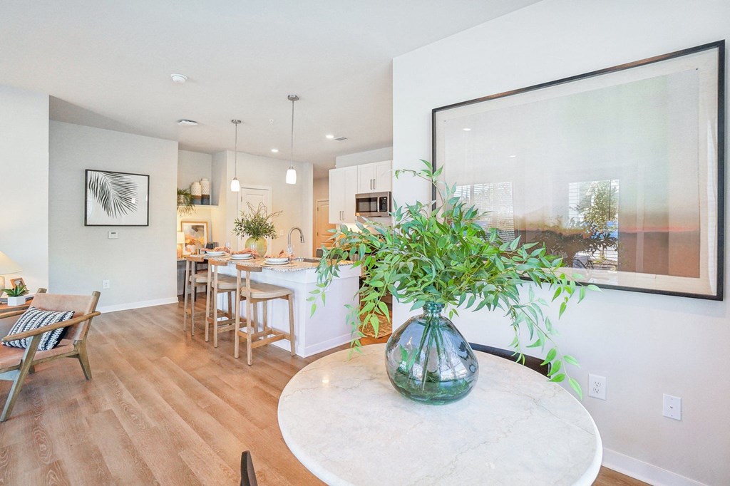 a living room and dining room with a table and a large window