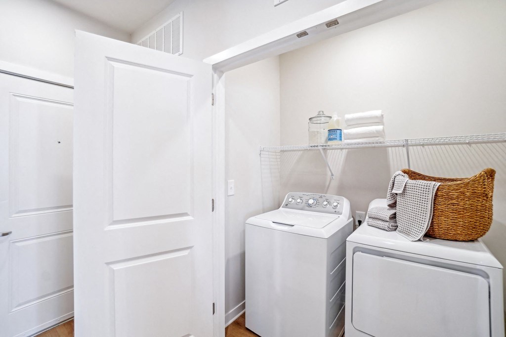 a small laundry room with a washer and dryer and a closet