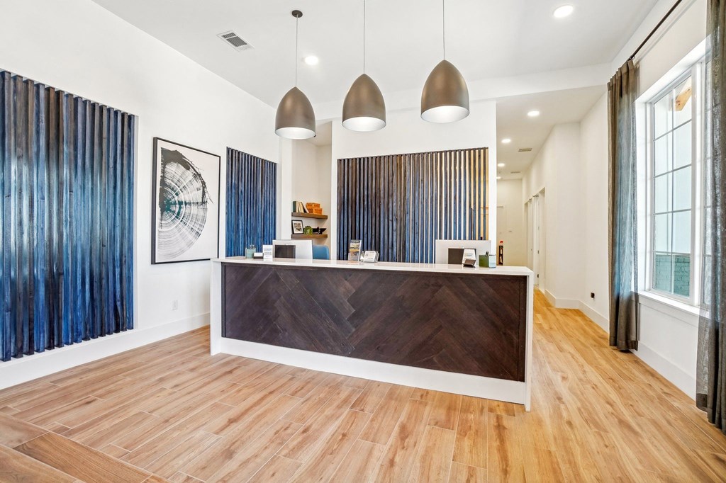 a reception area with a wooden desk and a large window