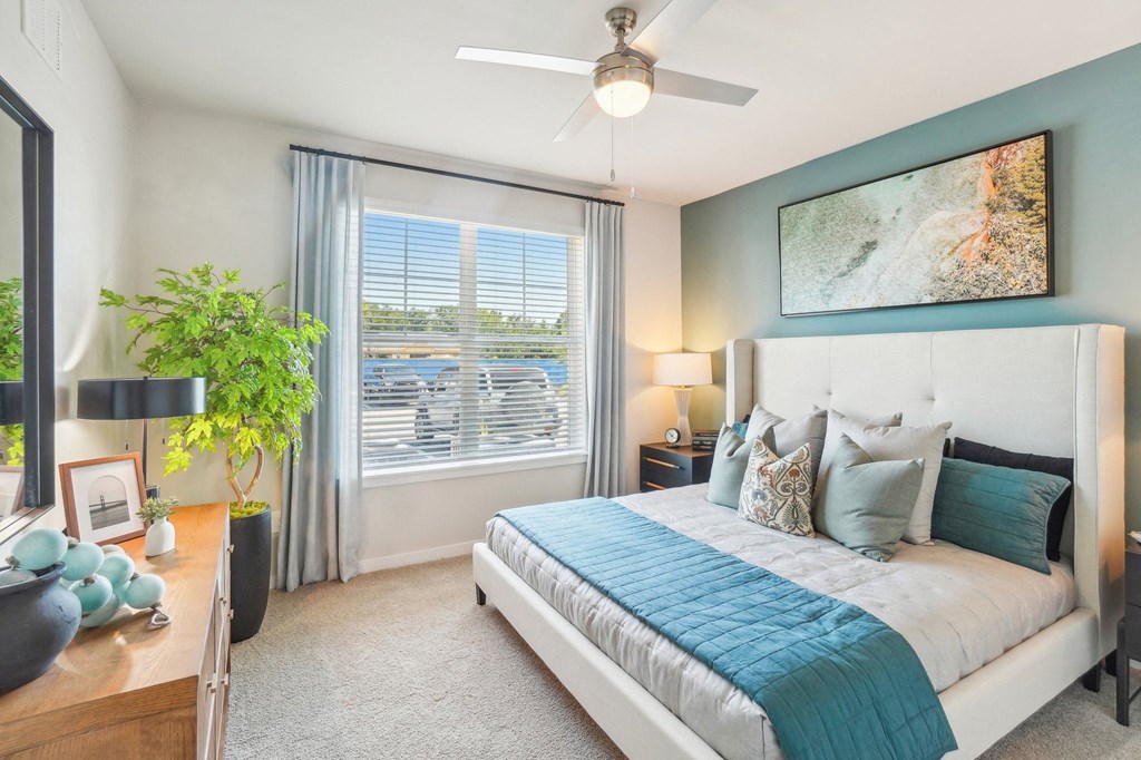 a bedroom with a bed and a ceiling fan