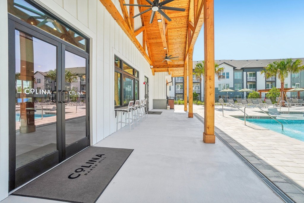 a long porch with a pool and a welcome mat on the floor