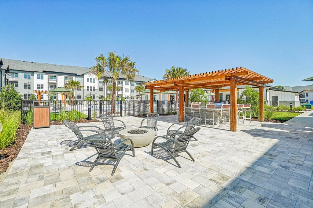 an outdoor patio with tables and chairs and a fire pit
