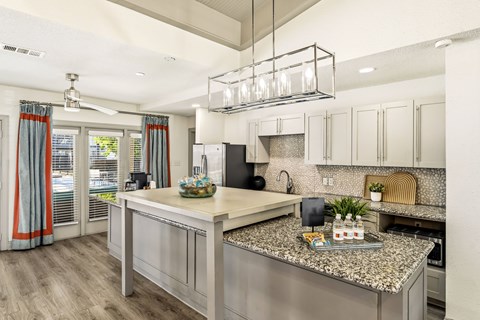 A modern kitchen with a large island and stainless steel appliances.