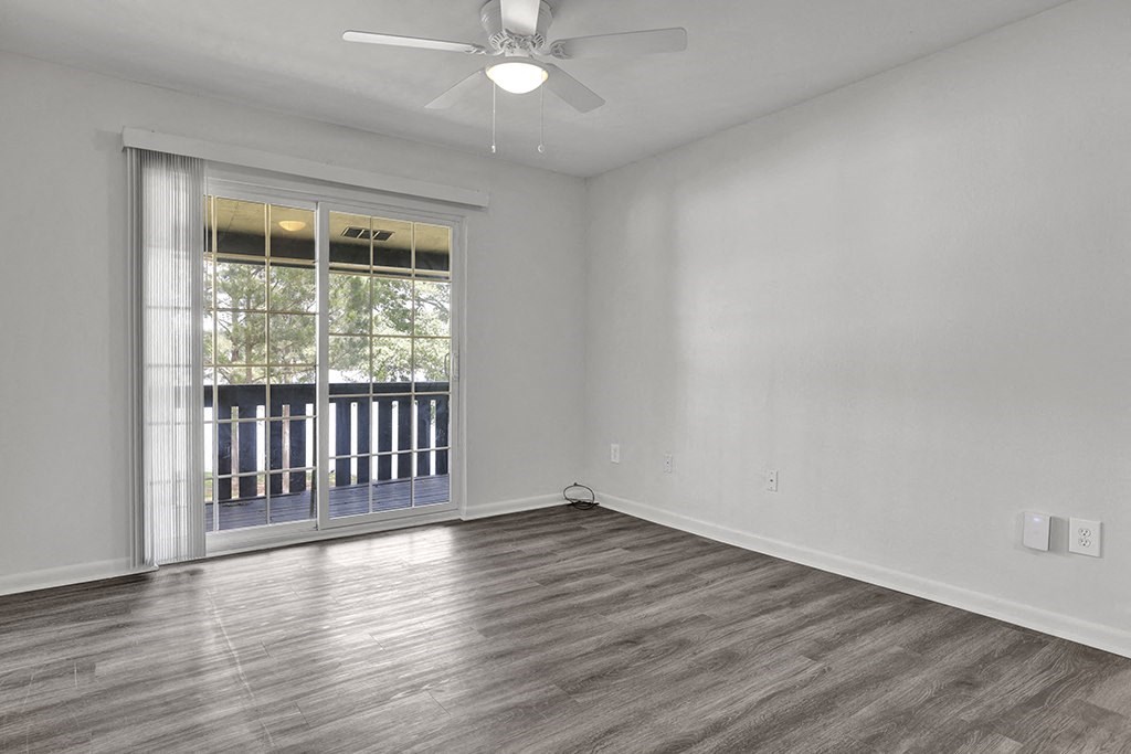 an empty living room with private balcony at Riverhouse Apartments in Riverside, Alabama