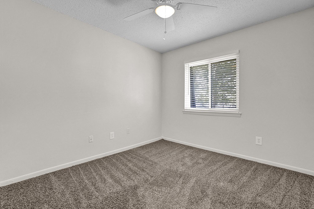 Bedroom with Large Window and Ceiling Fan at Riverhouse Apartments in Riverside, AL