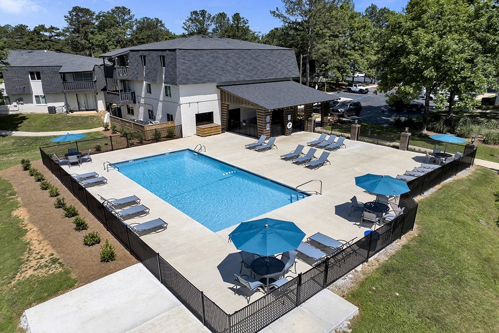 Swimming Pool with Seating and Umbrellas at Riverhouse Apartments in Riverside, AL