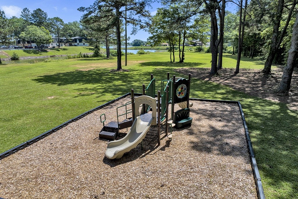 a playground with slides clubhouse and seating area at Riverhouse Apartments in Riverside, AL