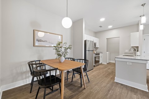 A modern kitchen with a dining table and chairs.