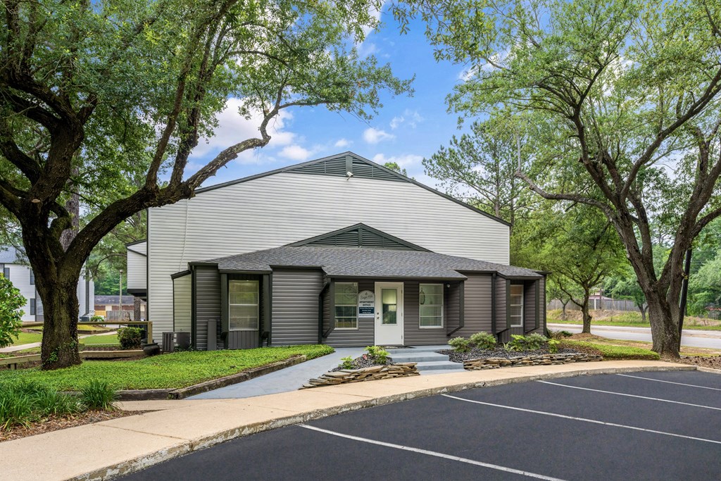 a white and gray building with trees in the background
