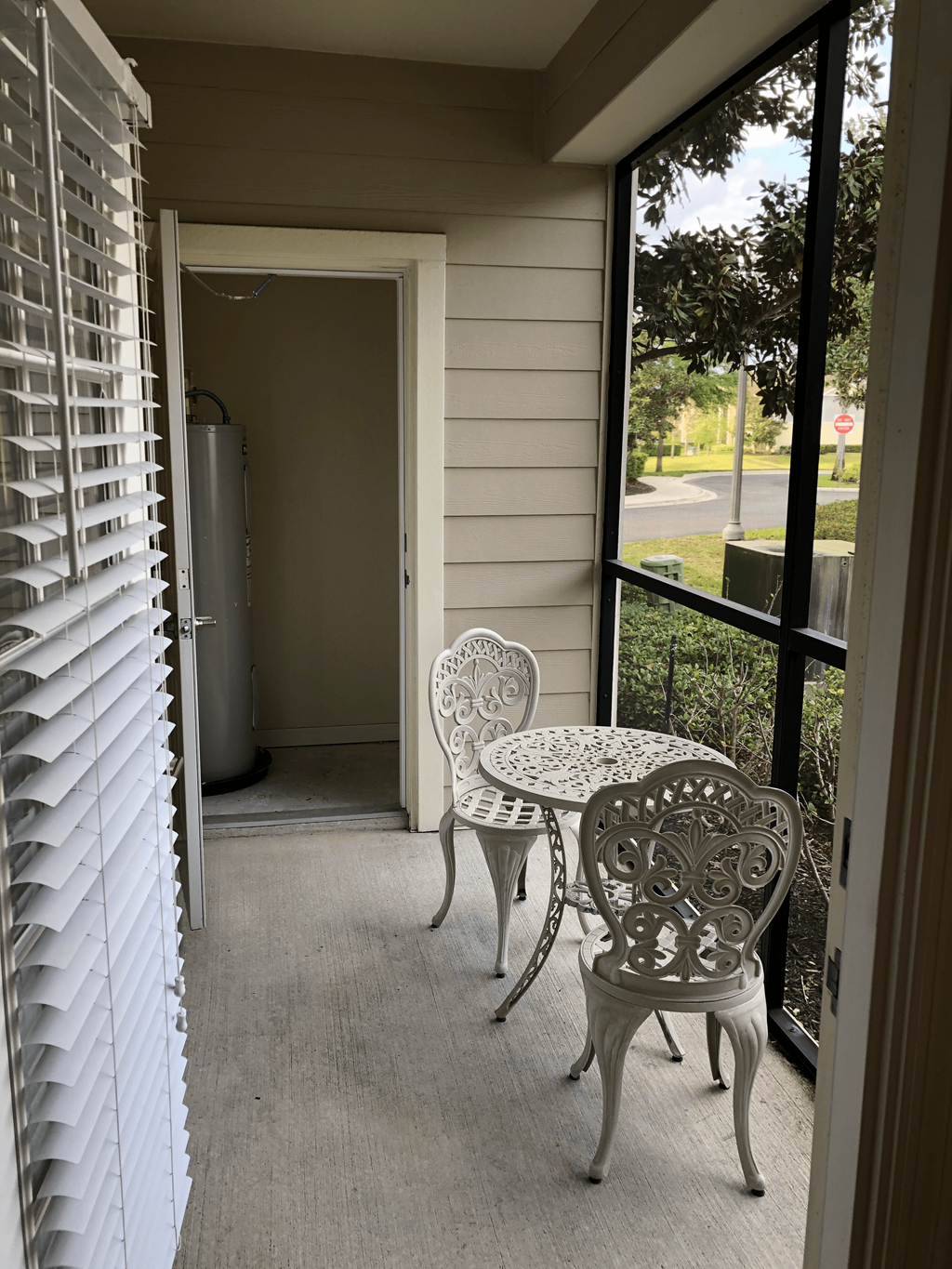 a porch with a table and two chairs and a sliding glass door