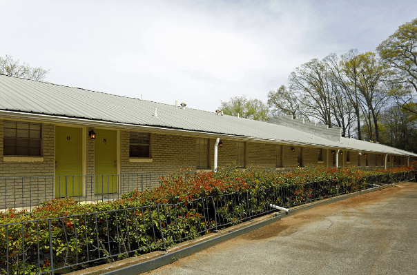 the front of a brick building with a metal fence
