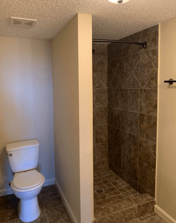 a bathroom with a toilet and a shower