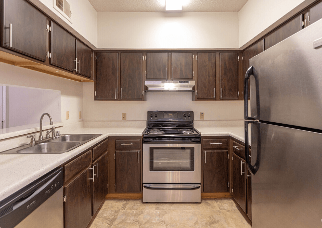a kitchen with stainless steel appliances and wooden cabinets