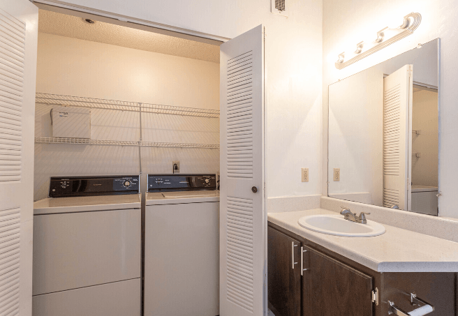 a bathroom with a sink and a mirror and a refrigerator