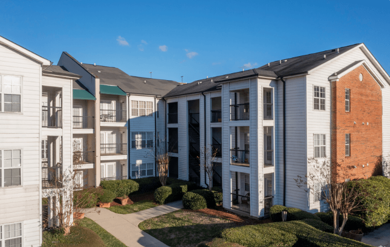 an apartment building with a sidewalk in front of it