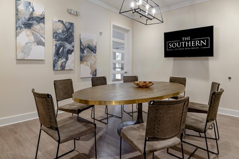 A dining room with a round table and chairs.